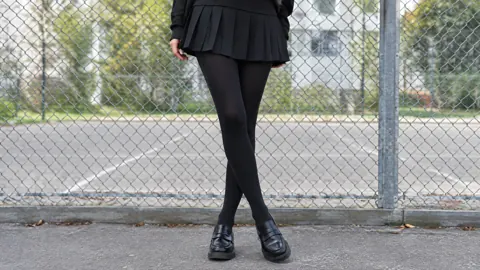 Woman in Skirt by Fence