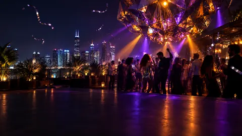 Rooftop Party Under Light Sculpture